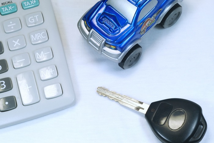Toy car, calculator, and keys representing Lexus financing